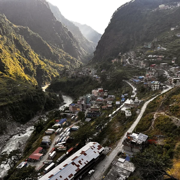 Aerial view of Syabrubesi village with river, mountain valley, and road gateway to the Langtang Valley Trek in Nepal