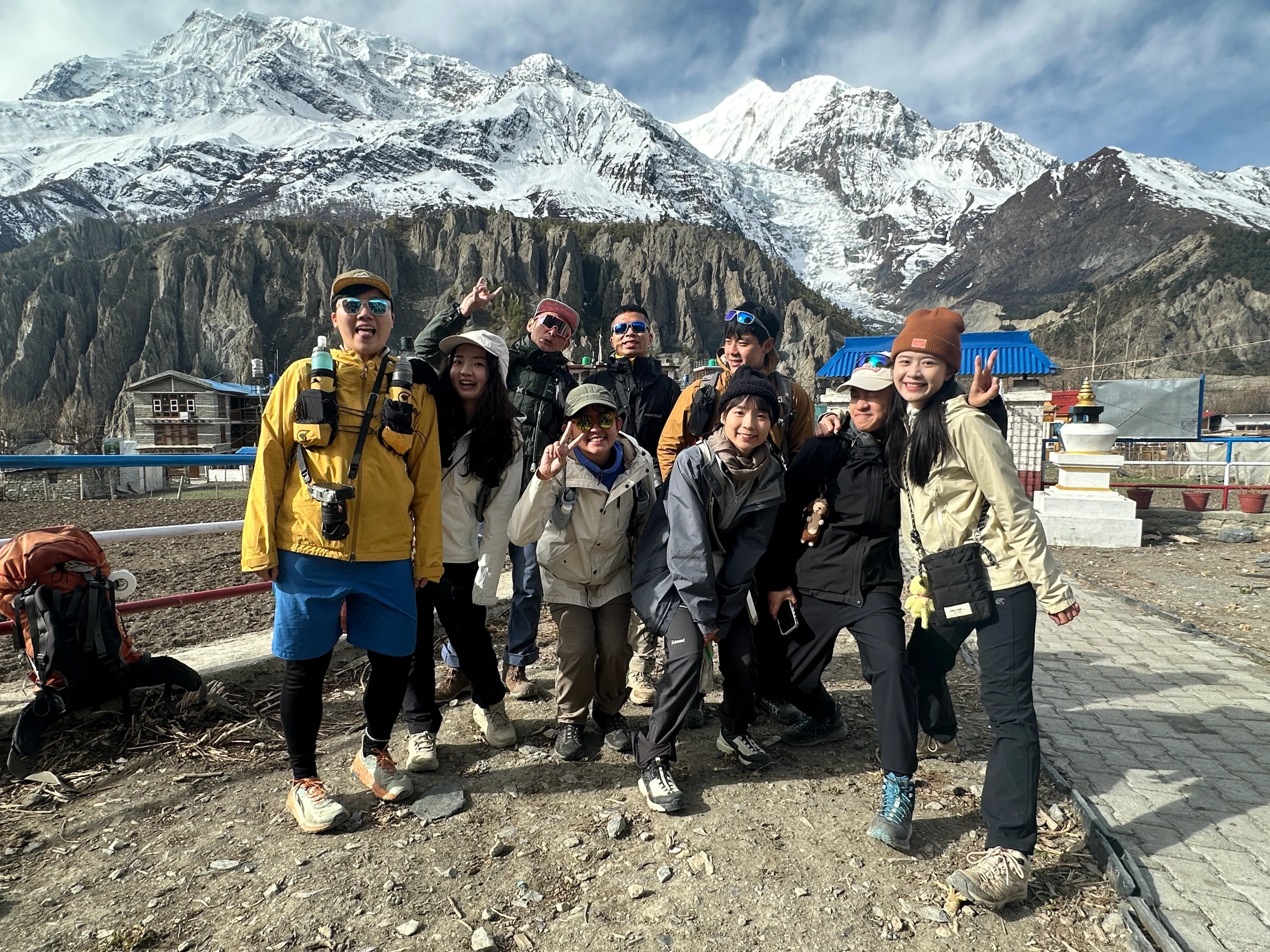 Group of trekkers posing in Manang, Nepal, with snowy Himalayan mountains