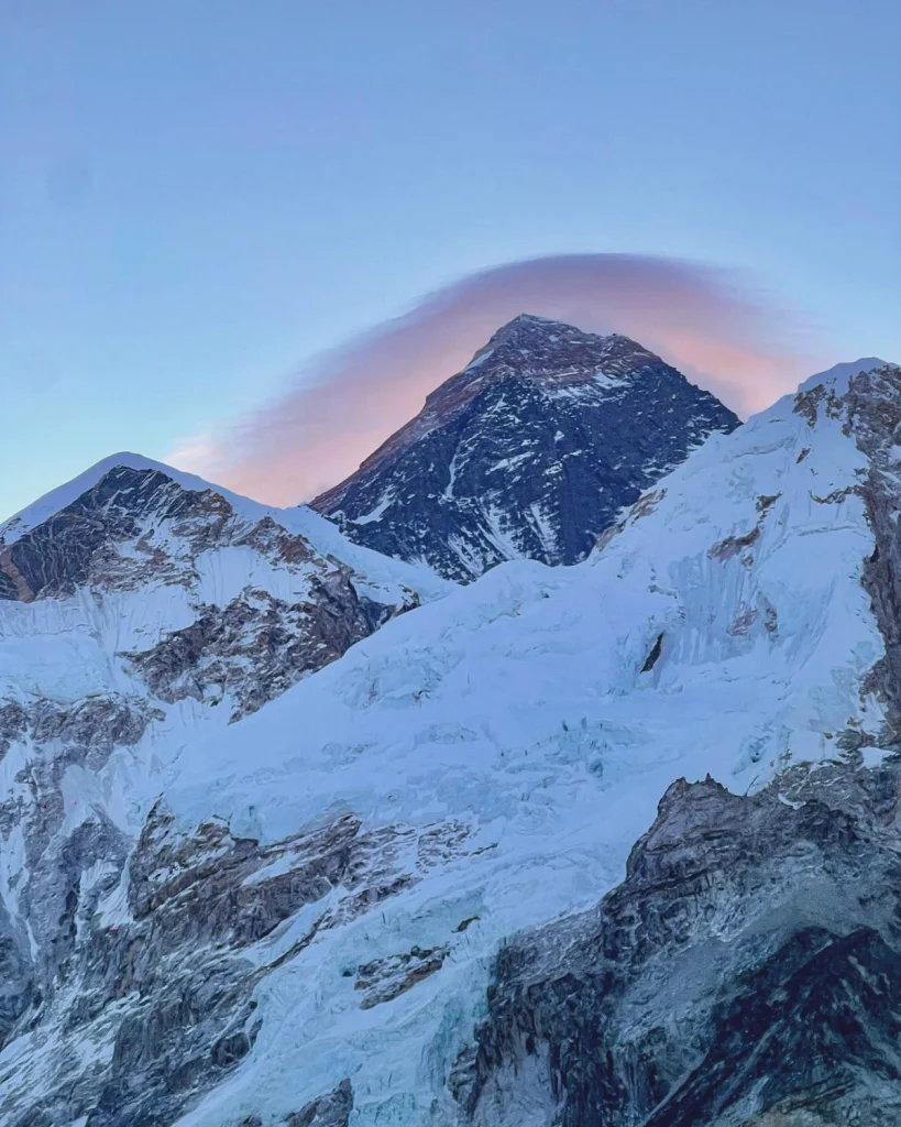 Mount Everest glowing during sunrise with snow-covered peaks and icy glaciers seen from the Everest Base Camp trekking route in Nepal.