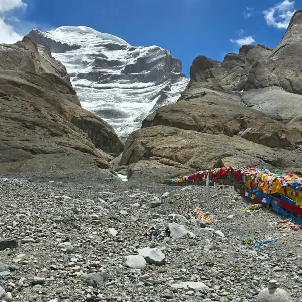 Mount Kailash and colorful prayer flags in Shizang under a clear blue sky.